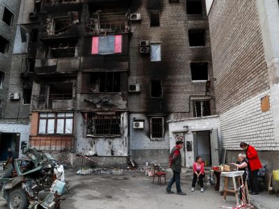 Мариупольцы возле жилого дома, пострадавшего от обстрелов, 15 мая 2022 года. Фото: Alexander Ermochenko / Reuters